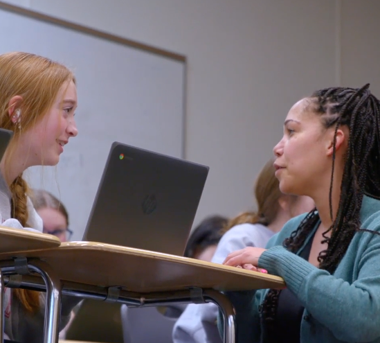 Student and teacher discuss lesson over computer